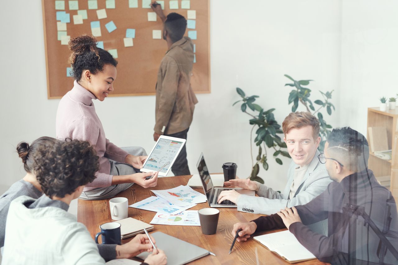 A diverse group of professionals discussing ideas in a modern office setting. Perfect for business and teamwork concepts.